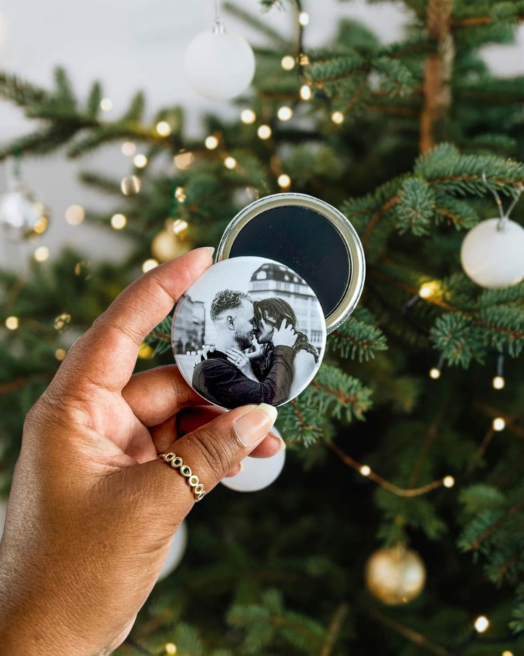 photo d'un magnet photo rond personnalisé de 5,8 cm devant un sapin de noël